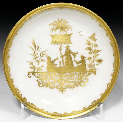 SAUCER WITH GOLD CHINESE FIGURES, MEISSEN, CIRCA 1720-24.Painted in Augsburg in the Seuter workshop with a group of three Chinese figures in a garden scene under a canopy. The edge with Augsburg gold border. D 12.5cm. Provenance: Private collection, Switzerland