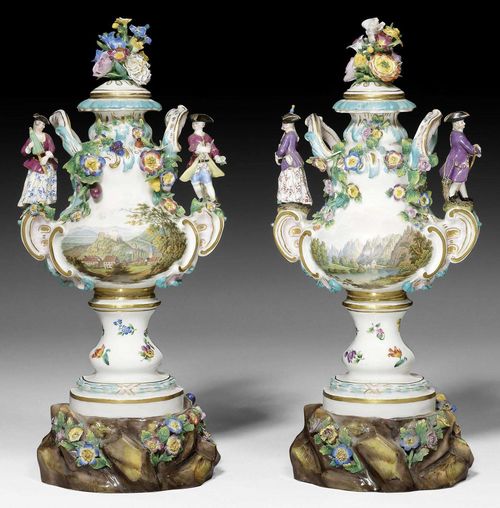 PAIR OF COVERED VASES WITH FIGURES, MEISSEN, 1ST HALF OF THE 19TH CENTURY.Shaped baluster forms with auricular handles with figures of a knight and a lady atop, the vases painted on both sides with mountainous landscape scenes, with applied flowers and leaves and heightened in turquoise, pink and gold. Each with a pierced lid. Underglaze blue sword mark on both undersides, one with incised model number. Old collector's label.  H 34cm. Minor chips.