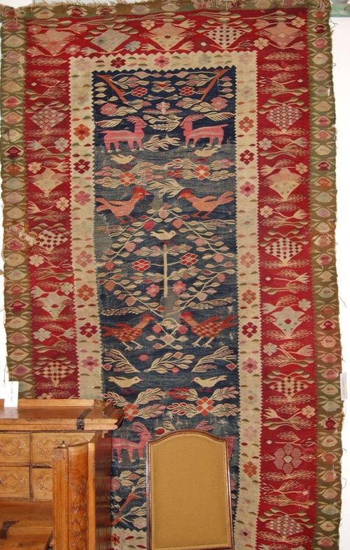 BESSARABIAN KELIM antique. Blue central field with animals and plants in harmonious colours, red border, strong signs of wear, 290x165 cm.