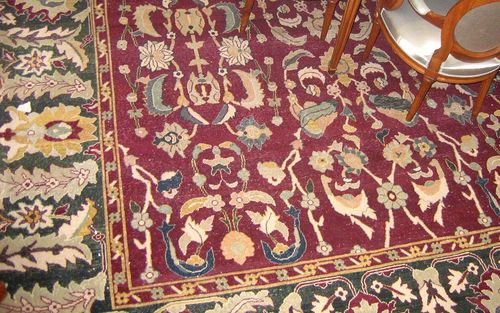 EUROPEAN AGRA old.Dark red ground, entirely patterned with flowers and palmettes in light colours, green border, signs of wear, 490x345 cm.