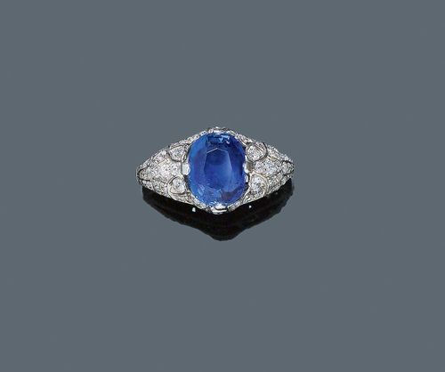 BURMA SAPPHIRE AND DIAMOND RING, ca. 1925. Platinum, shank white gold 750. Attractive ring, the openwork top decorated with a fine, antique-oval Burma sapphire of 4.57 ct, unheated, within a border of 60 diamonds weighing ca. 0.80 ct. Shank, not original. Size 60. With BGI Certificate No. BGI-18616/HG09.