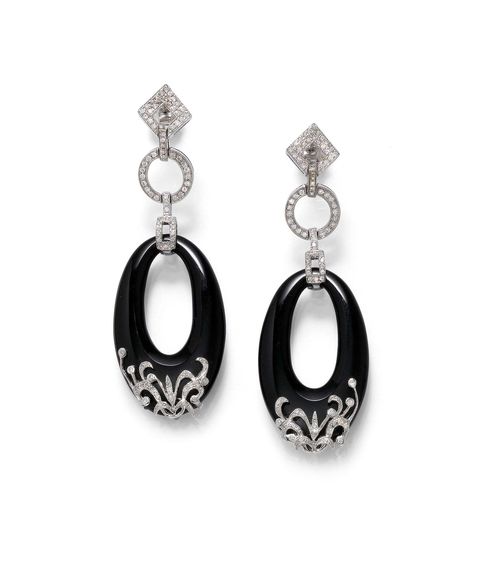 ONYX AND DIAMOND EAR PENDANTS. White gold 750. Casual-elegant ear studs, each of 1 oval onyx ring, decorated with 1 floral element set with brilliant-cut diamonds, suspended from 1 circular and 1 lozenge-shaped motif, set throughout with brilliant-cut diamonds. Total weight of the diamonds ca. 0.70 ct. L ca. 6.5 cm.