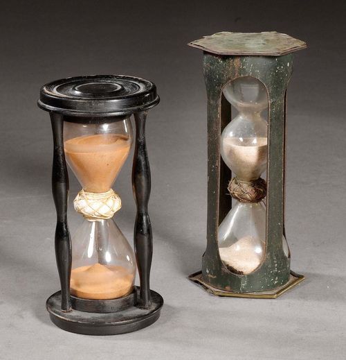 2 HOURGLASSES,Baroque, probably German, 18th century. The larger hourglass with dark metal holder, with three glass bulbs and beige sand; the smaller one with a probably later wooden holder, 2 glass bulbs and red sand. H 15 and 13.5 cm.