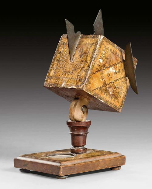 CUBIC SUNDIAL WITH COMPASS,late Baroque, inscribed D. BERINGER (David Beringer, 1756-1829), German circa 1800. Paper (colored copperplate engraving), iron and wood. 5 faces. With joint for adjusting the latitude, small compass in the base. Cube 6.7x6.7x6.7 cm. H 19 cm.