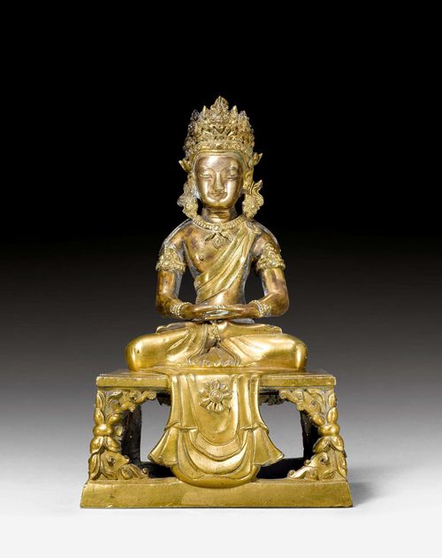 SEATED AMITAYUS.Sino-Tibetan, Qianlong Period, H 18.6 cm. Gilded bronze. Seated in the meditation posture on a high, quadrangular throne, the front adorned with a drape showing a flower. The hands in dhyana mudra originally held the vase with the elixir of life.