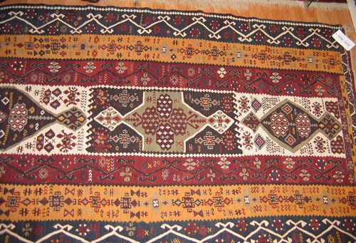 KILIM old.Black and white central field with cross-shaped medallions in grey and black, triple-stepped border in red, yellow and blue, geometrically patterned, good condition, 190x120