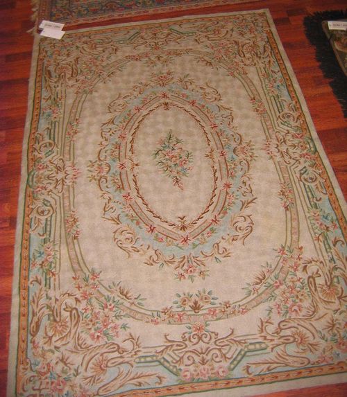 LOTZWILER old.Beige ground with a floral central medallion, the entire carpet is finely patterned with trailing flowers in light green and pink, good condition, 184x124 cm.