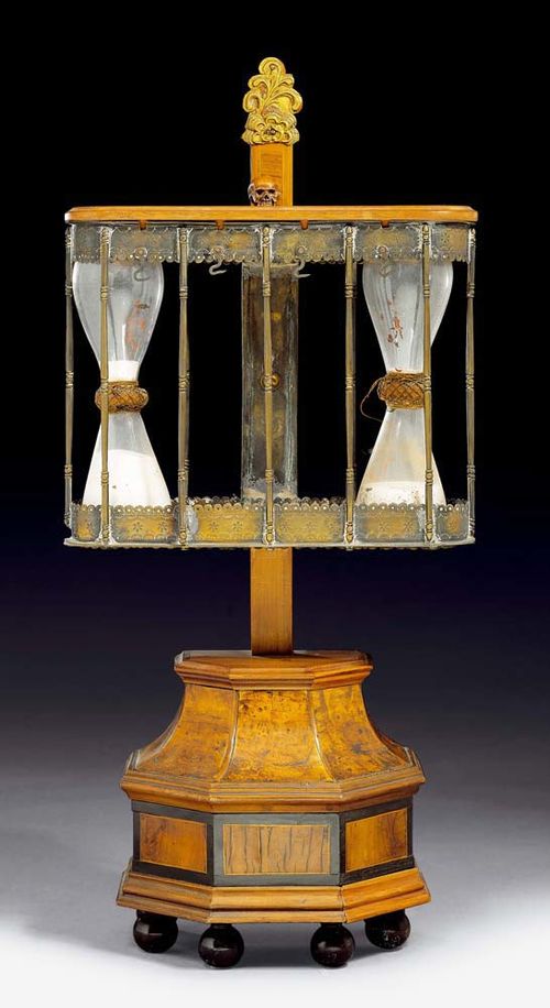 ORATORIAL SAND CLOCK,Early Baroque, monogrammed MM (Michael Mann, active circa 1600), Nuremberg circa 1600. Walnut and burlwood inlaid with ebony fillets and finely engraved relief-decorated brass. 2 sand clocks with remains of old paint in cage shaped case. Requires restoration. 2 sand clocks missing. H 48 cm. Provenance: Zurich private collection.