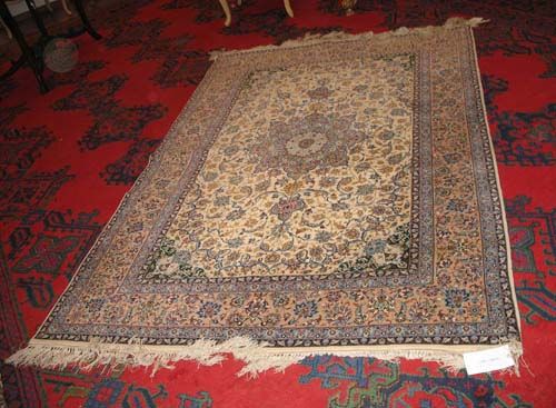 ISFAHAN old.White central field with beige central medallion and green corner motifs, patterned with trailing flowers and palmettes in light blue and beige. Light border. Good condition, 230x155 cm.