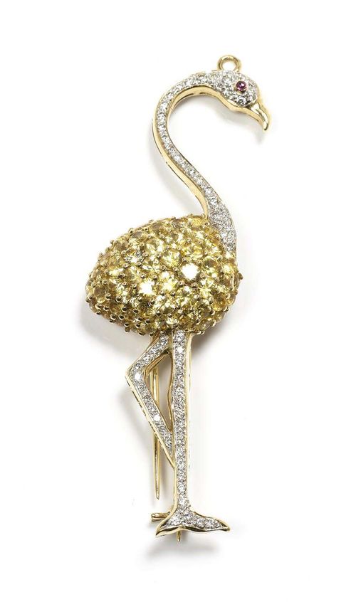 SAPPHIRE AND DIAMOND BROOCH / PENDANT. Yellow gold 750. Fancy brooch in the shape of a flamingo set with brilliant-cut diamonds, the body set throughout with yellow sapphires weighing ca. 3.00 ct. Total diamond weight ca. 0.70 ct. Hinged eyelet.