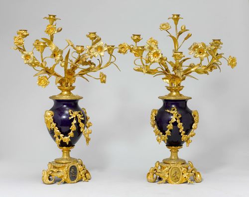 PAIR OF VASE-SHAPED CANDELABRAS,Napoléon III. Bronze. Shaft designed as a blue enamelled vase, the walls with flower garlands and 2 ram heads. 6 light branches. On a short, matching foot with putti medallion. H 62 cm.