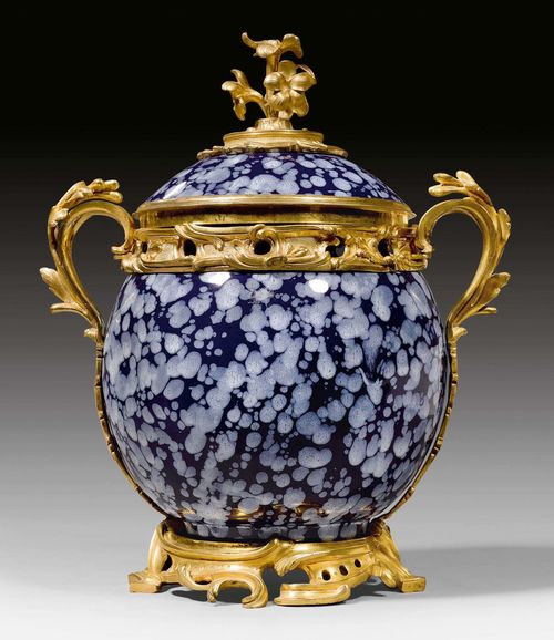 LIDDED VASE WITH BRONZE MOUNTS,Louis XV, the faience from the Nevers factory, 17th century, the bronzes Paris circa 1750. Blue/white faience "a decor de bougie" with matte and polished gilt bronze.  D 19 cm. H 32 cm. Provenance: - J. Perrin, Paris. - From a highly important European private collection.