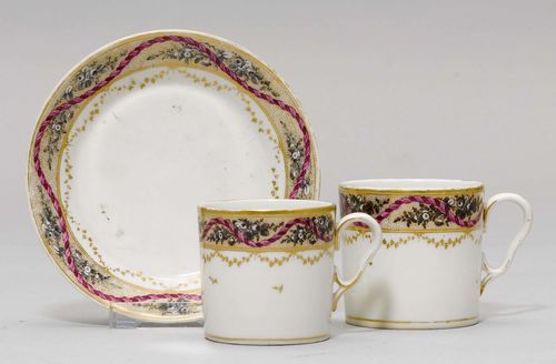 LOT OF 2 CUPS AND 1 SAUCER,Nyon, ca. 1781-1813. With grisaille flower border on a gold ground and purple corded border. Underglaze blue fish marks. Gilding rubbed. Provenance: Private collection, Geneva.
