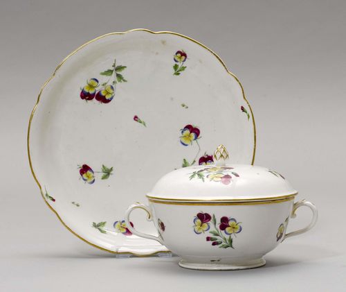ECUELLE WITH SAUCER,Nyon, ca. 1781-1813. Painted with violets, gold edge. Underglaze blue fish mark. D 17 and 22 cm. Hairline crack in the bottom of the ecuelle. Provenance: Private collection, Geneva.