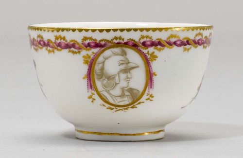 TEA CUP WITH MEDALLION 'EN GRISAILLE',Nyon, ca. 1781-1813. Painted with the portrait of a soldier in the antique style 'en grisaille', in an oval medallion with gold decoration and a 'dentils d'or' border. Underglaze blue fish mark. Provenance: Private collection, Geneva.