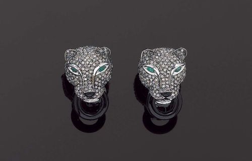 DIAMOND AND ONYX CLIP EARRINGS. White gold 750. Decorative, elegant clip earrings, stud earrings in the shape of 2 panther heads, each holding an onyx ring, entirely set with 456 diamonds, totalling ca.  1.50 ct., with 2 navette-cut emeralds as eyes.