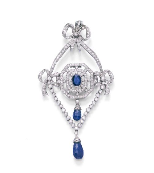 SAPPHIRE AND DIAMOND PENDANT. White gold 750. Decorative pendant in the style of ca. 1910, with garlands and band and bow motifs set with diamonds, and with the centre set with 1 oval sapphire weighing ca. 1.00 ct, additionally decorated with 2 sapphire briolettes as pendants. Total weight of the diamonds ca. 2.00 ct, and of the briolettes ca. 3.00 ct. Ca. 8.3 x 4.5 cm.