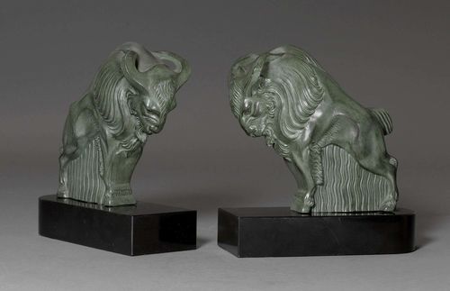 BOOKENDS DESIGNED AS A RAM,late Art Deco, France, 20th century. Cast zinc, green patinated. On a black marble base. H 23 cm. One is disconnected.