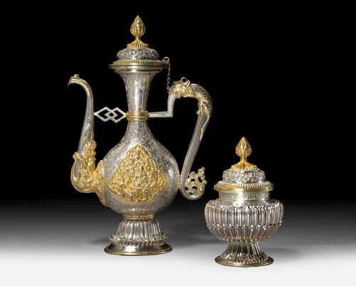 RITUAL JUG AND COVERED POT.Tibet, H 22 and 11 cm. Silver with areas of gilding, engraved ornament and high relief cartouches. Identical lids.