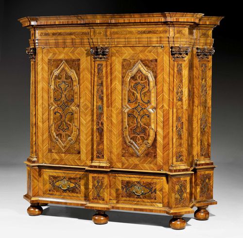 IMPORTANT HALL CABINET WITH 5 PILASTERS, Baroque, by J.H. BUDDE (Johann Hermann Budde, maitre 1774), Warendorf in Muensterland circa 1780. Walnut, burlwood and various fruitwoods in veneer with exceptionally fine inlays. Large iron lock. Bronze mounts and drop handles. 220x86x225 cm.