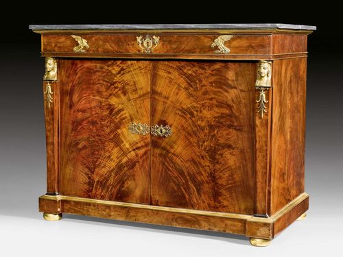 PRINCELY SIDEBOARD "AUX BUSTES DE SPHINGES", known as a "commode a portes avec tiroirs a l'anglaise", Empire, stamped JACOB FRERES RUE MESLEE (cooperation between the brothers George II and Francois-Honore-George Jacob 1796-1803), Paris circa 1803. Flame Cuban mahogany in veneer. The front with two doors below a top drawer. Interior with 3 drawers. Exceptionally fine, matte and polished gilt bronze mounts and applications. "Bleu Turquin" top. 116x61x90 cm. Provenance: - Traditionally considered to be formerly part the collections of Prince Murat in Chateau Chambly, Oise. - From a European collection.