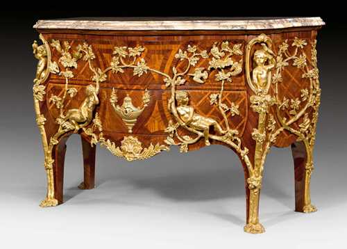IMPORTANT COMMODE "AUX ENFANTS", Regence style, after an imperial model by C. CRESSENT (Charles Cressent, maitre 1720), attributed to F. LINKE (Francois Linke, 1855-1946), Paris circa 1900. Purpleheart and rosewood in veneer with exceptionally fine inlays. Slightly salient front with 2 drawers. Exceptionally rich, matte and polished gilt bronze mounts and applications. Light brown, black veined onyx top. 148x62.5x93 cm.