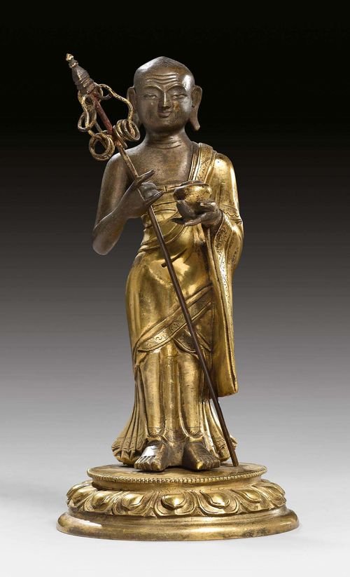A GILT COPPER ALLOY BEGGING MONK CARRYING HIS ALMS BOWL. Tibeto-chinese, 18th/19th c.  Height 16 cm.