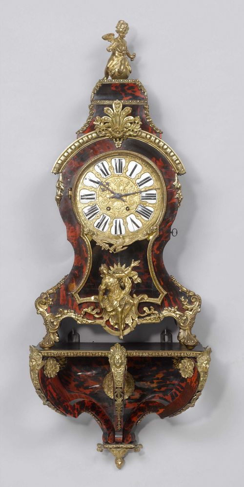 CLOCK ON BASE,Regency style, France. Wood inlaid with red tortoiseshell and applied with bronze mounts designed as rosettes, mascarons, friezes, etc.  Bronze dial, applied with enamel cartouches. Movement with anchor escapement striking the 1/2-hour on bell. H 110 cm. Striking mechanism requires servicing.