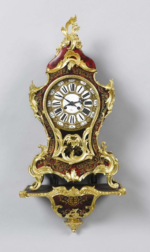 SMALL BOULLE CLOCK ON BASE,Regency style, France. Wooden case with red tortoiseshell and inlaid with engraved brass tendrils and flowers.  Bronze mounts. Bronze dial, applied with white enamel cartouches. Movement with anchor escapement striking the 1/2-hour on bell. H 75 cm.