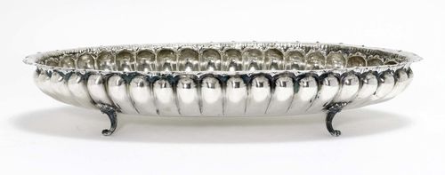 OVAL, FOOTED PLATE,silver, 20th century. Oval form with gadrooned walls all around and protruding rim. On four scroll feet. 60x32 cm, 1535 g.