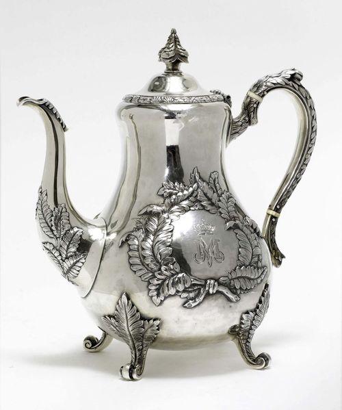 COFFEE POT,London, 1865/66. Maker's mark: Richard Hennell. Pear-shaped. On four scroll feet. Curved spout and handle. Convex cover with finial. Walls with leaf cartouches and with crowned, engraved initials. H 26 cm, 970 g.