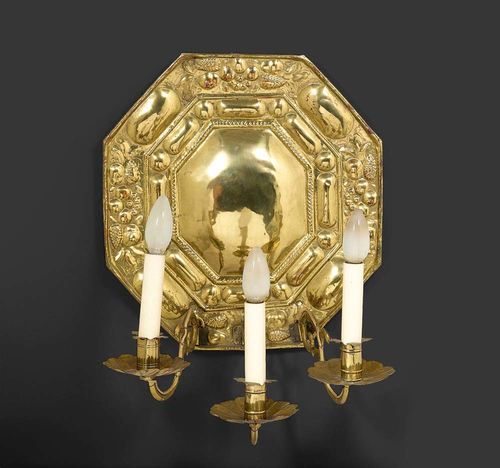 BLAKER, Baroque, German, 18th century Moulded brass. Octagonal wall plaque with fine relief and three shaped light branches. Fitted for electricity. H 54 cm. Provenance: Private collection Zurich.