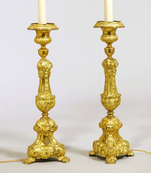 PAIR OF ALTAR CANDLESTICKS CONVERTED TO TABLE LAMPS, in the Baroque style, Italy, 19th century. Brass, chased and gilt. Baluster shaft. H 73 cm. Small repairs. Fitted for electricity.