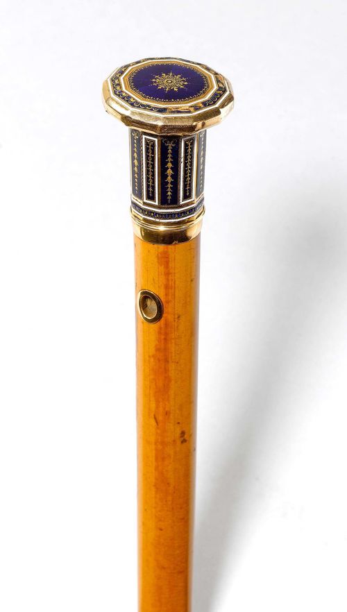 WALKING STICK, France, ca. 1820. 12-edged gold handle with blue enamelled decoration. Moluccan wood, the top pierced. Bone tip. L 90.5 cm. Chipped.