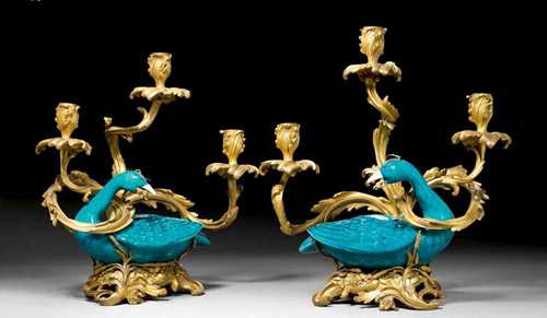 PAIR OF CANDELABRAS "AU CANARD",Louis XV, the bronzes Paris, the porcelain probably China, 18/19th century Matte and polished gilt bronze and blue-green porcelain. Featuring a duck on a pierced scrolled plinth with frogs, reeds and other plants. Fitted for electricity. H 39 cm. Provenance: Private collection, Germany.