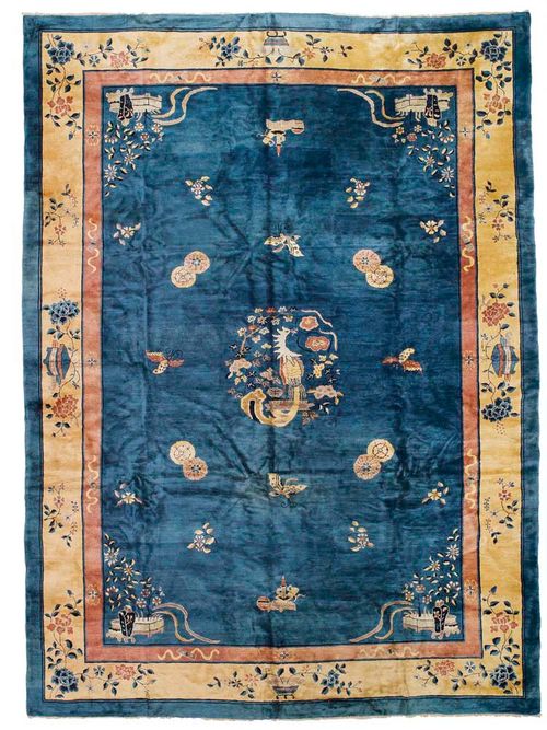 CHINA old.Blue central field decorated with depictions of flowers and animals in light colours, yellow border, slightly stained, otherwise in good condition, 430x310 cm.
