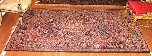KESHAN old.Blue central field with a red central medallion and corner motifs, the entire carpet is finely patterned with trailing flowers and palmettes, blue border, slight wear, 210x130 cm.