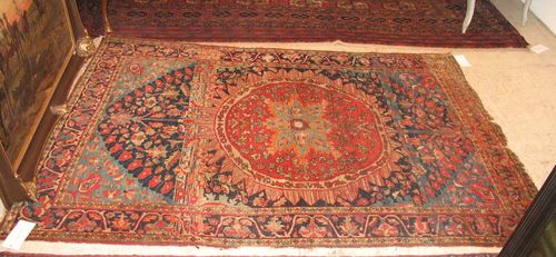 SAROUGH FERAGHAN antique.Dark blue ground with light blue corner motifs and a red central medallion, the entire carpet is decorated with stylized floral motifs in harmonious colours, black border, strong signs of wear, 195x135 cm.