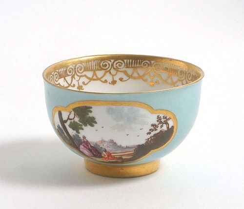 CUP WITH LANDSCAPE CARTOUCHES, Meissen, circa 1745. Gold framed cartouches on both sides on a turquoise ground. In the base a further landscape cartouche in iron red double ring. Gold border. Underglaze blue sword mark.