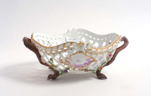 PORCELAIN BASKET, Meissen, circa 1780.Pierced and with applied trailing floral sprays. Also with a rocaille cartouche enclosing landscape scene and floral bouquet on each side, painted in Purpur Camaïeu and heightened in gold. Underglaze blue sword mark, star and II. Model number A.35. incised D 20cm/23.5cm.