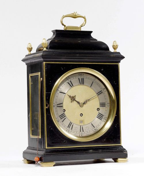 BRACKET CLOCK WITH CARILLON AND DATE,England, ca. 1765. The dial and movement signed JOHN ELLICOTT LONDON (John Ellicott 1706-1772). Rectangular case in black-painted wood, glazed on all sides. Brass fronton with silver-plated chapter ring and small date window. Engraved plate. Movement with verge escapement, striking the 1/4-hour on bell, and carillon with 6 bells. Repetition on demand as well as silent mode. 27x17x47 cm.