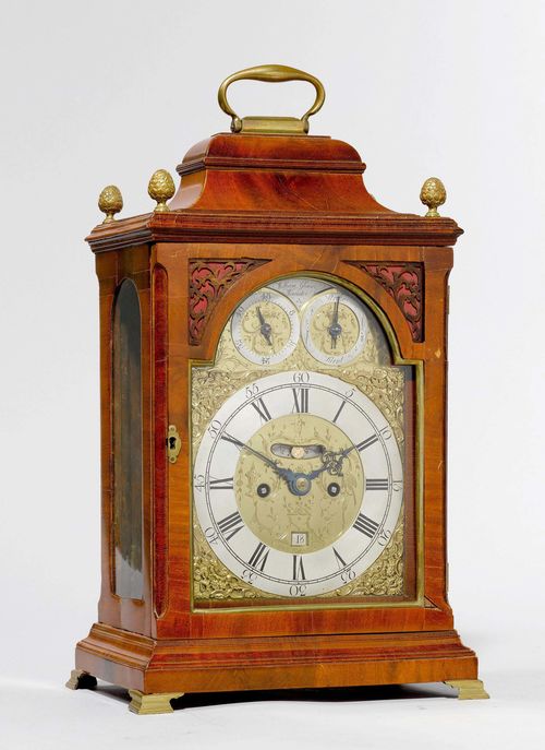 BRACKET CLOCK WITH CARILLON AND DATE,George III, England, ca. 1770. The dial signed WILLIAM GLOVER WORCESTER. Rectangular, mahogany case, glazed on all sides. Retracted top. Applied brass fronton, silver-plated chapter ring and 2 auxiliary dials for power reserve and setting the striking mechanism. Date window and visible pendulum. Plate, finely engraved with tendrils. Movement with verge escapement, striking the hour on bell. Repetition, striking the hours on 6 bells.27x17x46 cm. 1 key. Case requires some repair.