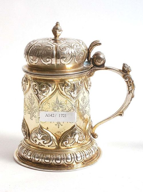 TANKARD AND LID. Nuremberg  18th century. Maker's mark . With continuous egg and dark ornament. Hexagonal form with engraved decoration. Cast handle. Parcel gilt. H 15 cm. 330 g.