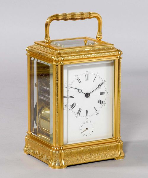TRAVEL ALARM CLOCK, France, Napoleon III, end of the 19th century. Brass, engraved with shells, flowers and tendrils, and gilt. Rectangular case with handle, glazed on all sides. White enamel dial with small chapter ring for alarm. Movement with balance, striking mechanism, optionally with Grande Sonnerie, striking the hour on gongs or silent mode. Alarm on gong. 9x8x14 cm. 1 key. Striking mechanism requires revision.