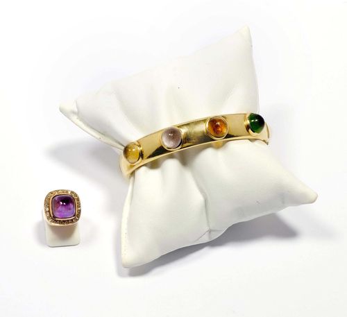 GEMSTONE BANGLE AND RING, ca. 1960. Yellow gold 585, 36g and 9g. Casual bangle with hinge, the outside set with 4 gemstone cabochons of ca. 9 mm Ø, amethyst, peridot, citrine, rock crystal. Signs of wear. Ca. 6 x 5.2 cm. Matching ring set with 1 square amethyst cabochon of ca. 10.6 x 10.6 mm, within a border of small single-cut diamonds. Size ca. 51.