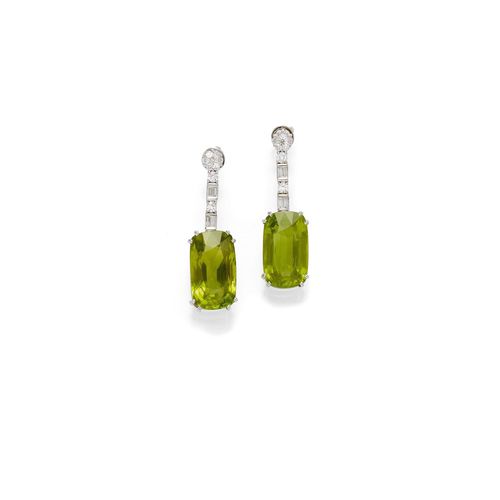 PERIDOT AND DIAMOND EAR PENDANTS. White gold 750. Casual-elegant ear pendants with studs, each set with 1 elongated, antique-oval Burma peridots, weighing 36.75 ct in total, flexibly suspended from a line of 2 baguette-cut diamonds, 2 brilliant-cut diamonds and 1 diamond-set rosette motif. Total diamond weight ca. 2.10 ct. L ca. 4 cm. With Stalwart Report, No. 1261819, February 2013.