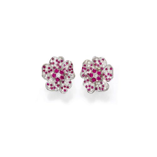 RUBY AND DIAMOND EAR CLIPS. White gold 585. Decorative ear slips, designed as a sculptured blossom, set throughout with numerous treated rubies, weighing ca. 3.60 ct in total, and brilliant-cut diamonds, weighing ca. 1.50 ct in total.