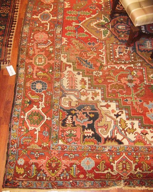 HERIZ antique.Red ground with a central medallion and white corner motifs, typically patterned, red border, strong signs of wear, 350x300 cm.
