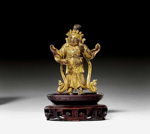 A GILT BRONZE FIGURE OF THE HEAVENLY KING OF THE EAST. Tibeto-Chinese, 19th c. Height 8 cm. Wood base.