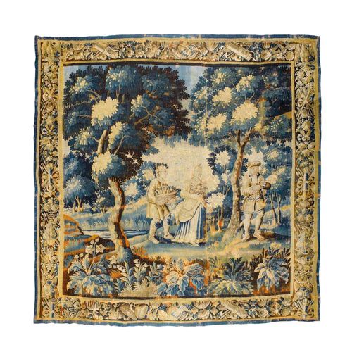 VERDURE TAPESTRY,early Baroque, France, 17./18th century Depicting figures carrying baskets of fruits in an idealised forest landscape. Fine floral and foliate border. H 170 cm, W 240 cm.